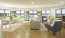 a large living room area with windows, chairs and a couch