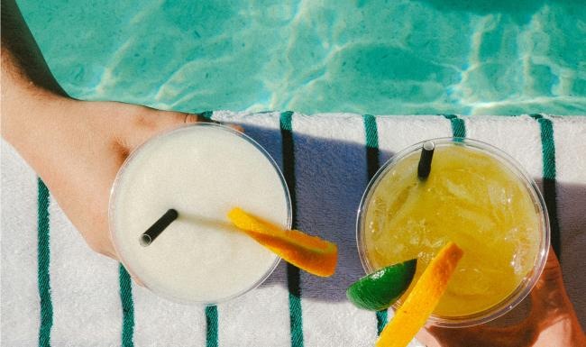 Relax and unwind poolside people holding drinks while swimming